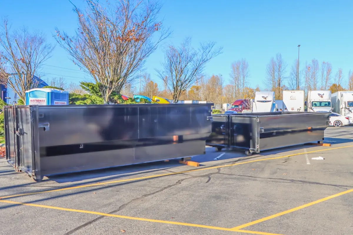 Professional dumpster rental service with roll-off container on residential driveway in Dexter